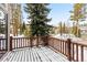 Snow-covered deck with wood railings offers scenic views of surrounding trees at 293 Settlers Dr, Breckenridge, CO 80424