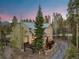 Stunning exterior view of a multi-story home surrounded by lush trees against a beautiful twilight sky at 293 Settlers Dr, Breckenridge, CO 80424