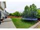 Lush backyard with green grass, a trampoline, mature trees, and a concrete patio at 1995 E 166Th Ave, Thornton, CO 80602