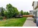 Level backyard with green grass, trees, a trampoline, and a concrete patio with grill at 1995 E 166Th Ave, Thornton, CO 80602