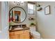 Charming powder room features a round mirror and stylish decor at 1995 E 166Th Ave, Thornton, CO 80602