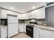 Cozy kitchen featuring white cabinetry, granite countertops, and modern black appliances at 14852 E Kentucky Dr # 928, Aurora, CO 80012