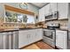 This modern kitchen offers stainless steel appliances, granite countertops, tile backsplash, and white cabinets and trim at 720 Reid Pl, Castle Rock, CO 80108