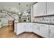 Open kitchen with hardwood floors, white cabinetry, granite countertops, and view of the staircase at 720 Reid Pl, Castle Rock, CO 80108