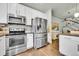 Modern kitchen with stainless steel appliances, white cabinets, hardwood floors, and an open layout at 720 Reid Pl, Castle Rock, CO 80108