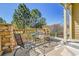 Cozy patio with metal furniture, stone columns, and serene views of lush greenery and blue skies at 720 Reid Pl, Castle Rock, CO 80108