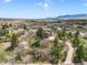 Aerial view of a beautiful home with mature landscaping and a winding driveway at 18750 Spring Valley Rd, Monument, CO 80132