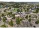 Aerial view of a home and yard surrounded by mature trees in a quiet neighborhood at 18750 Spring Valley Rd, Monument, CO 80132