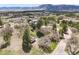 Aerial shot of a home with outbuildings on a sunny day with mountains in the background at 18750 Spring Valley Rd, Monument, CO 80132