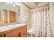 Bathroom featuring tile countertops, white sink, decorative shower curtain and a wood door at 18750 Spring Valley Rd, Monument, CO 80132