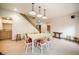 Open dining room featuring a white table set for six and a wet bar with light wood cabinets at 18750 Spring Valley Rd, Monument, CO 80132