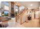 Entryway and open staircase lead to the living area with a stone fireplace and oversized windows at 18750 Spring Valley Rd, Monument, CO 80132