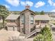 Charming two-story home featuring a stone chimney, two-car garage, and an inviting elevated deck with mountain views at 18750 Spring Valley Rd, Monument, CO 80132