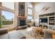 Open living room with soaring ceilings, stone fireplace, and large windows showcasing mountain views at 18750 Spring Valley Rd, Monument, CO 80132
