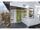 Close-up of the bright green front door and newly painted white exterior with dark trim at 5505 Brentwood St, Arvada, CO 80002