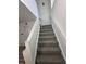 Clean staircase with carpeted treads, white risers, and railing leading to the upper level at 11113 E Alameda # 207, Aurora, CO 80012