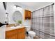 Compact bathroom featuring a round mirror, wood vanity, and shower with curtain at 5425 County Rd 32 # 27, Mead, CO 80504