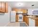 Well-maintained kitchen featuring wood cabinets, white appliances, and a tile floor at 5425 County Rd 32 # 27, Mead, CO 80504