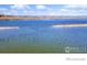 Scenic lake view with abundant wildlife and serene blue waters under a partly cloudy sky at 5425 County Rd 32 # 27, Mead, CO 80504
