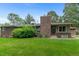 Expansive backyard featuring a brick home, lush greenery, and mature trees, perfect for outdoor enjoyment at 2717 S Langley Ct, Denver, CO 80210