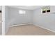 Spacious basement with carpet, neutral walls, bright window, and baseboard heater at 2717 S Langley Ct, Denver, CO 80210