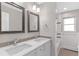 Bright bathroom featuring a double vanity, modern fixtures, framed mirrors, and tile backsplash at 2717 S Langley Ct, Denver, CO 80210