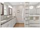 Modern bathroom featuring double sinks, stylish fixtures, a glass shower, and decorative tiling at 2717 S Langley Ct, Denver, CO 80210