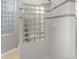 Modern bathroom with unique glass block window allowing natural light and white tile with decorative accents at 2717 S Langley Ct, Denver, CO 80210
