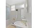 Bright bathroom featuring a sleek pedestal sink, modern fixtures, and a unique glass block window at 2717 S Langley Ct, Denver, CO 80210