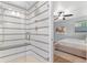 Bright tiled walk-in shower adjacent to bedroom with ceiling fan at 2717 S Langley Ct, Denver, CO 80210
