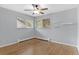 Bright bedroom featuring hardwood floors, modern ceiling fan, two bright windows, and shelves at 2717 S Langley Ct, Denver, CO 80210