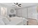 Neutral bedroom featuring modern ceiling fan, hardwood floors, and ensuite bathroom at 2717 S Langley Ct, Denver, CO 80210