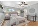 Cozy bedroom with hardwood flooring, a ceiling fan, lots of natural light and adjoining bathroom at 2717 S Langley Ct, Denver, CO 80210