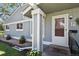 A welcoming front porch with decorative planters, stone landscaping, and a white trimmed front door at 2557 S Dover St # 12, Lakewood, CO 80227
