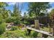 Backyard landscaped with rock garden pond, mature trees, and log benches offers tranquil retreat at 14797 E Temple Dr, Aurora, CO 80015
