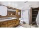 Bathroom featuring tiled floors, wood cabinets, and shower with a bathtub and curtain at 14797 E Temple Dr, Aurora, CO 80015