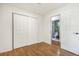 Bedroom features hardwood floors, closet, and a door leading to the bathroom with tiled shower at 14797 E Temple Dr, Aurora, CO 80015