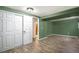 Bedroom features hardwood floors, closet, and a door leading to the bathroom with brown walls at 14797 E Temple Dr, Aurora, CO 80015