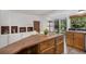 A kitchen island with a sink and butcher block countertop and open shelving with natural light at 14797 E Temple Dr, Aurora, CO 80015