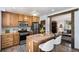 Efficient kitchen features wooden cabinets, stainless steel appliances, and an open layout leading to the living room at 14797 E Temple Dr, Aurora, CO 80015