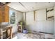 Unfinished shed with a rustic work bench and shelving for potting supplies with a window at 14797 E Temple Dr, Aurora, CO 80015