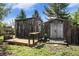 Multiple rustic sheds in backyard on landscaped lot with mature trees offer excellent outdoor storage options at 14797 E Temple Dr, Aurora, CO 80015