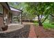 Spacious backyard features a covered patio, mature trees and brick path leading to lawn at 11351 Quivas Way, Denver, CO 80234