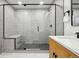 Stylish bathroom boasting a black-framed shower, dual vanity, and white tile floors at 11351 Quivas Way, Denver, CO 80234