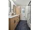 Modern bathroom has dual sink vanity, black tile floors and walk-in shower at 11351 Quivas Way, Denver, CO 80234