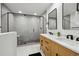 Modern bathroom featuring stylish shower, a dual sink vanity, and neutral decor at 11351 Quivas Way, Denver, CO 80234