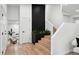 Elegant entryway featuring a black brick accent wall, wooden stairs, and a glimpse into the living area at 11351 Quivas Way, Denver, CO 80234