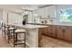 Bright kitchen featuring white cabinetry, an island with seating, modern countertops, and stainless steel appliances at 11351 Quivas Way, Denver, CO 80234