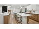 Open kitchen with white cabinets, stainless steel appliances, and extended island with seating at 11351 Quivas Way, Denver, CO 80234