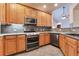 Kitchen featuring stainless steel appliances, oak cabinets, and stone tile floors at 22834 E Davies Dr, Aurora, CO 80016